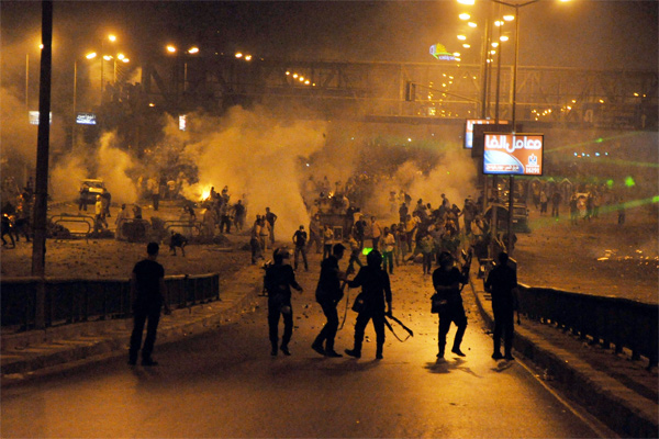 Egyptian supporters of the deposed Egyptian president Mohamed Morsi (back) clash with riot police in Cairo early on July 27, 2013. Mass rallies by supporters and opponents of Mohamed Morsi swept Egypt Friday, as the authorities formally detained the ousted Islamist president accusing him of conspiring with the Palestinian group Hamas. AFP PHOTO (Photo credit:STR/AFP/Getty Images)