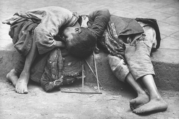 Two small children dying together in the gutter in the Chinese famine of 1946
