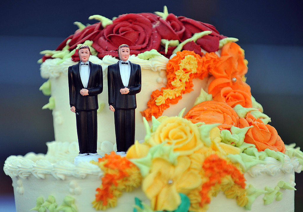 A wedding cake with statuettes of two me