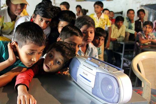 School children listen to a radio broadcast given by Indian prime minister Narendra Modi in 2014