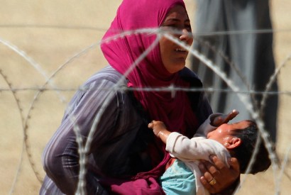 A mother and child, refugees from Raqqa, wait to cross into Turkey in September 2014