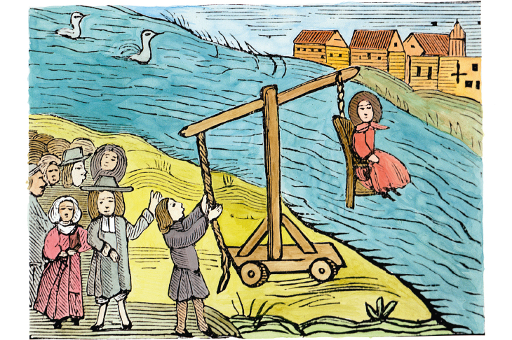 A woman on a ducking-stool, accused of witchcraft. Drowning would have proved her innocence