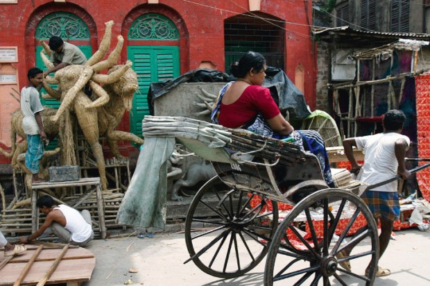 Deity sculptors work on a preliminary structure for the ten-armed Goddess Durga in preparation for the Durga Puja festival