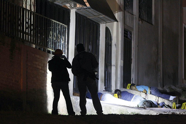 A nightly occurrence in Tegucigalpa. Forensic officers inspect a crime scene involving the execution of six men in drug-related gang warfare