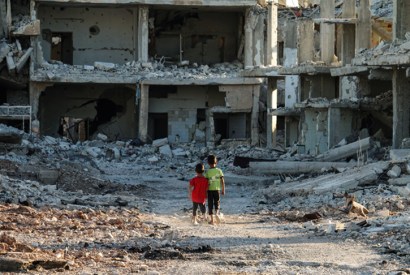In rebel-held territory, two boys contemplate the rubble of Daraa, September 2017