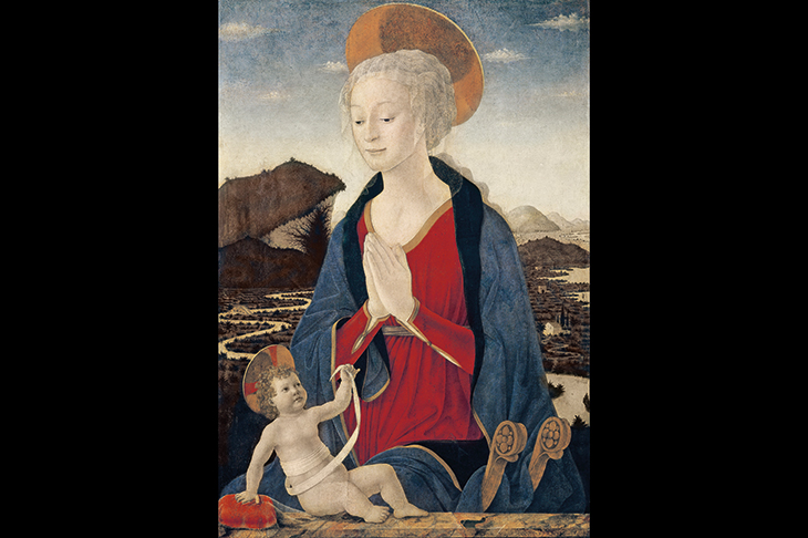 Alesso Baldovinetti’s ‘Madonna and Child’ (c. 1464) is rich in symbolism. The infant Christ holds his swaddling band up to the Virgin’s womb, as if it were a token of the umbilical cord that united them. The winding shape of the bandage is echoed in the distant meandering river. The Madonna’s gossamer veil falls over her head as a pyx-cloth might cover a sacramental vessel.The child touches another translucent veil, draped over the cushion beside him. Towering above him, his Mother joins her hands in devotion, as if to acknowledge her Son’s meaningful gestures