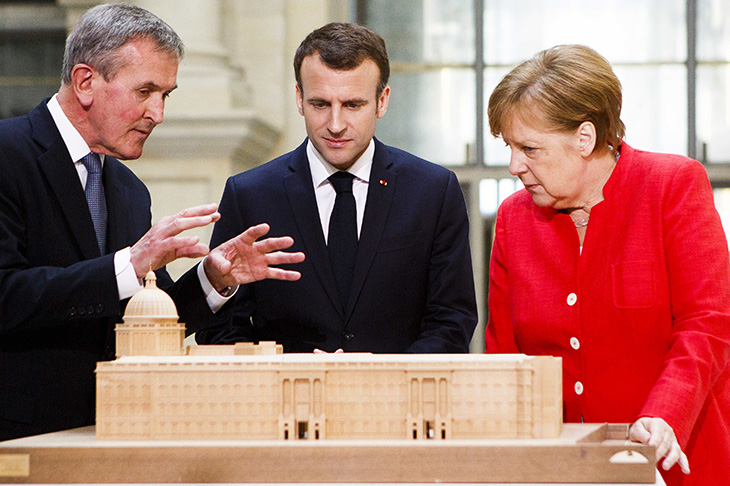 Neil MacGregor shows German Chancellor Angela Merkel and French President Emmanuel Macron a model of the new Humboldt Forum. Photo: Carsten Koall / Getty Images