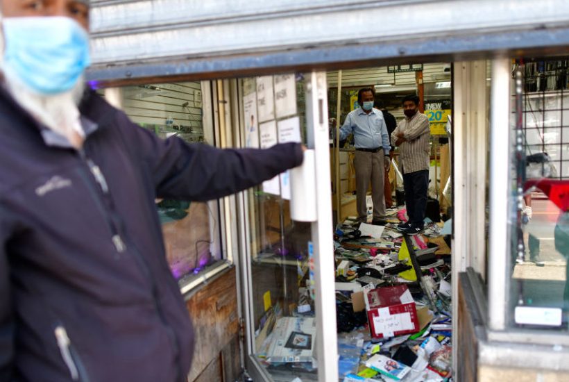 small Shop owners survey the damage to their store in Philadelphia, PA