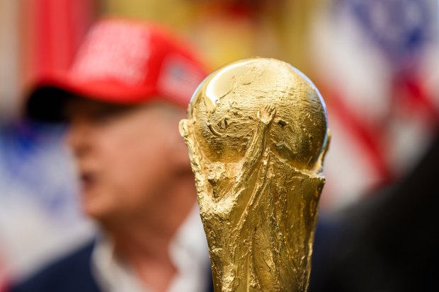 The soccer World Cup trophy sits in front of President Donald Trump