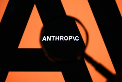 The Anthropic logo is displayed on a computer screen photographed through a magnifying glass in Creteil, France, on April 21, 2026. The image is taken amid reports of the NSA using Claude Mythos Preview despite a ban on Anthropic for United States government agencies. (Photo by Samuel Boivin/NurPhoto via Getty Images)